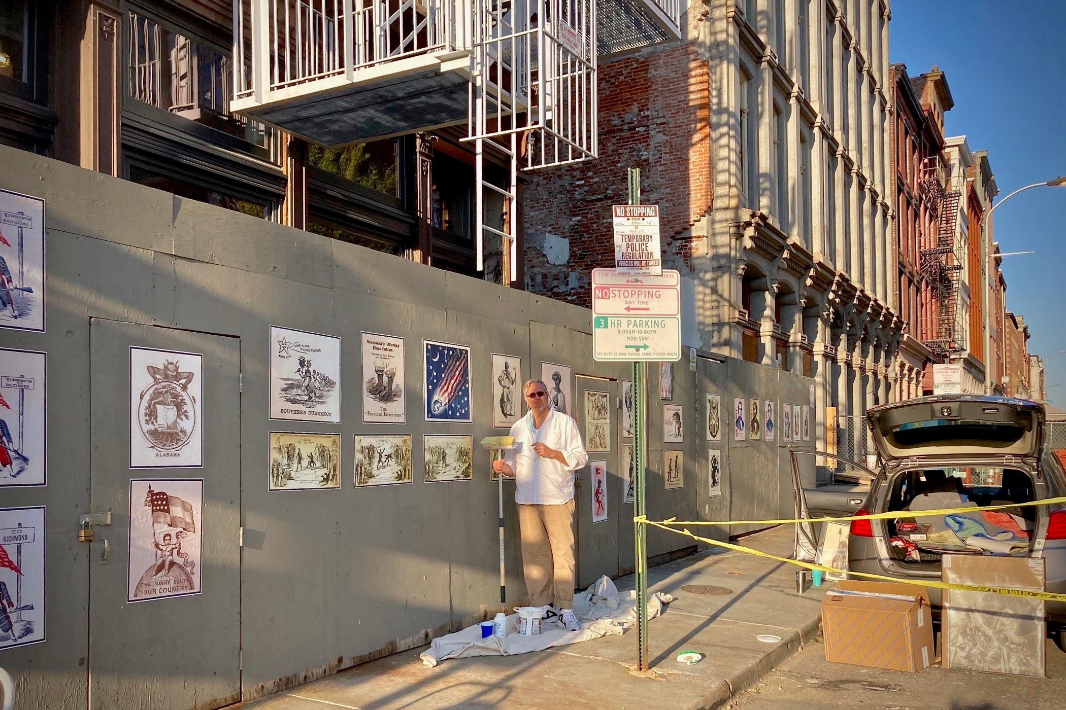 Printmaker Todd Kimmell installs a series of Civil War Era political cartoons on a construction wall at 3rd and Chestnut streets. (Courtesy of Todd Kimmell)