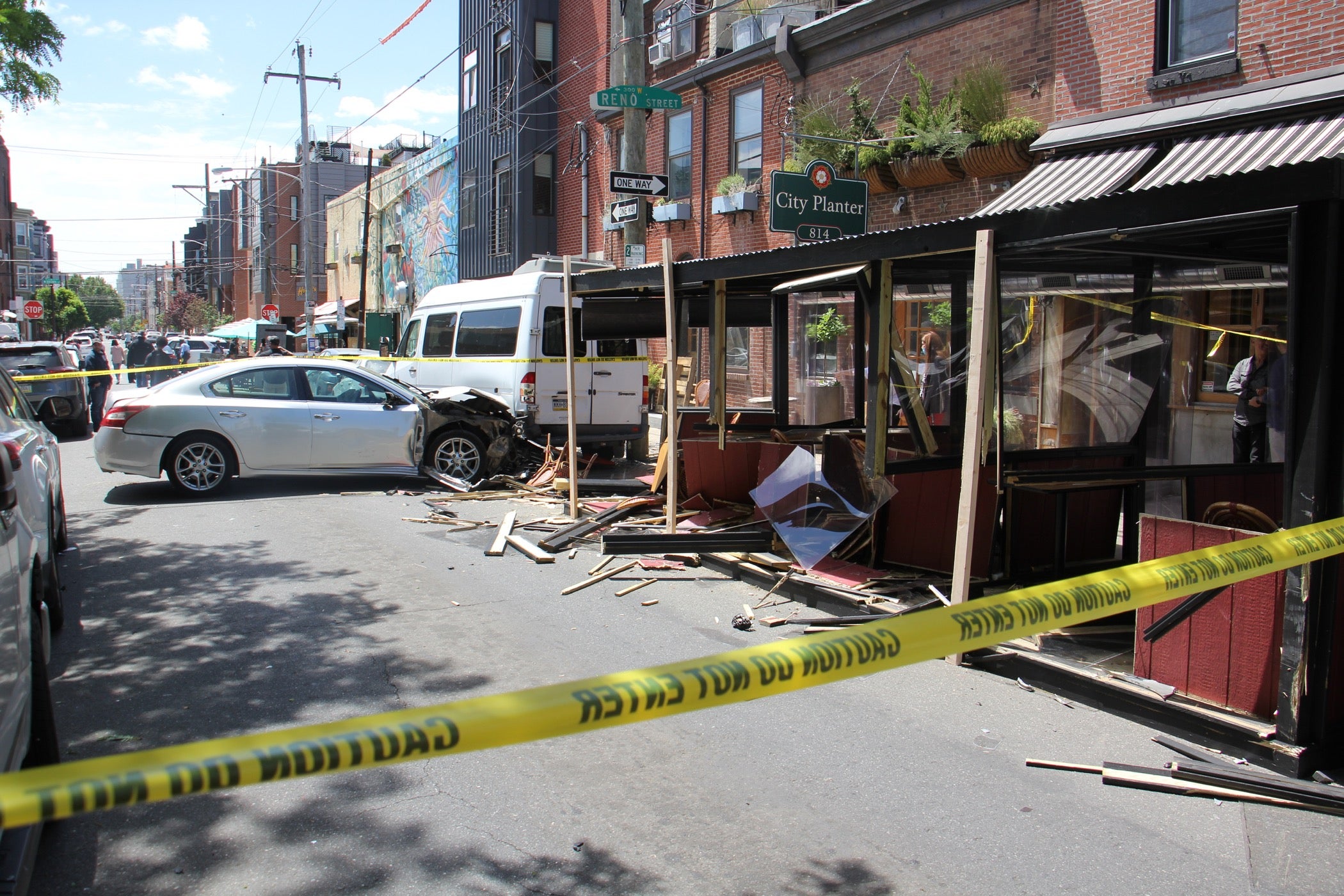 Fourth Street in Northern Liberties is closed to traffic while police investigate. A car tore the side off an outdoor dining structure before crashing into a parked van. Several patrons at Cafe La Maude were injured. (Emma Lee/WHYY)