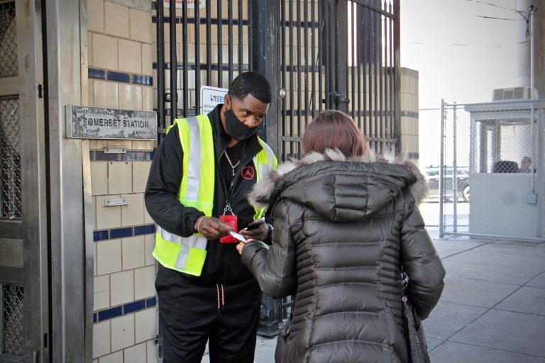 Outreach worker Kenneth Harris engages with a client outside Somerset Station. (Emma Lee/WHYY)