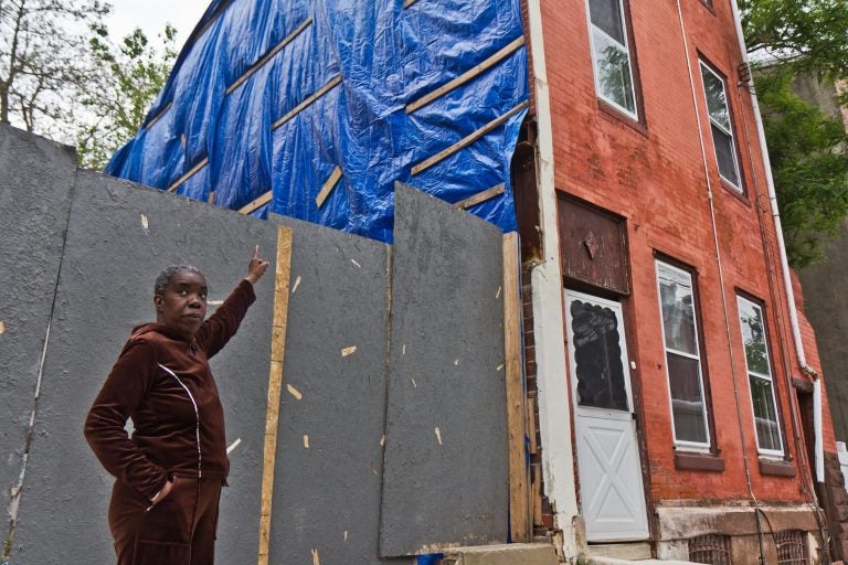 Clarice Brooks points to damage on the side of her home caused by construction on North 7th Street. The house has been owned by her family for 66 years. (Kimberly Paynter/WHYY)