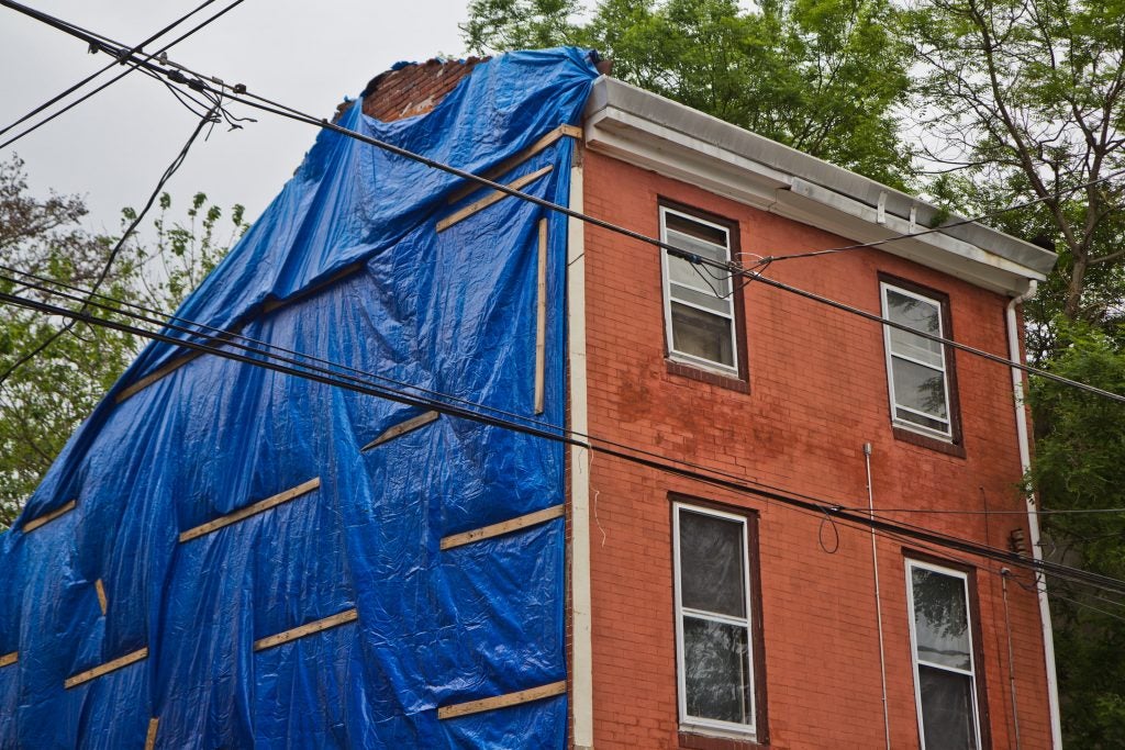 Repair work underway on the side of the Brooks family’s home on North 7th Street in Philadelphia. (Kimberly Paynter/WHYY)