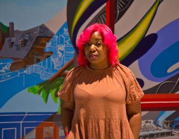 Artist Serena Saunders with her mural 'The Path' at the Bulletin Building across from 30th Street Station in Philadelphia. (Kimberly Paynter/WHYY)