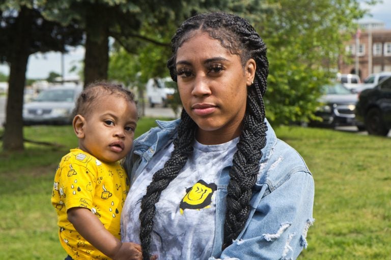 Asia Pratt holds her son Azi, while protesting conditions for people who are incarcerated at the Curran-Fromhold Correctional Facility in Northeast Philadelphia on May 7, 2021. (Kimberly Paynter/WHYY)