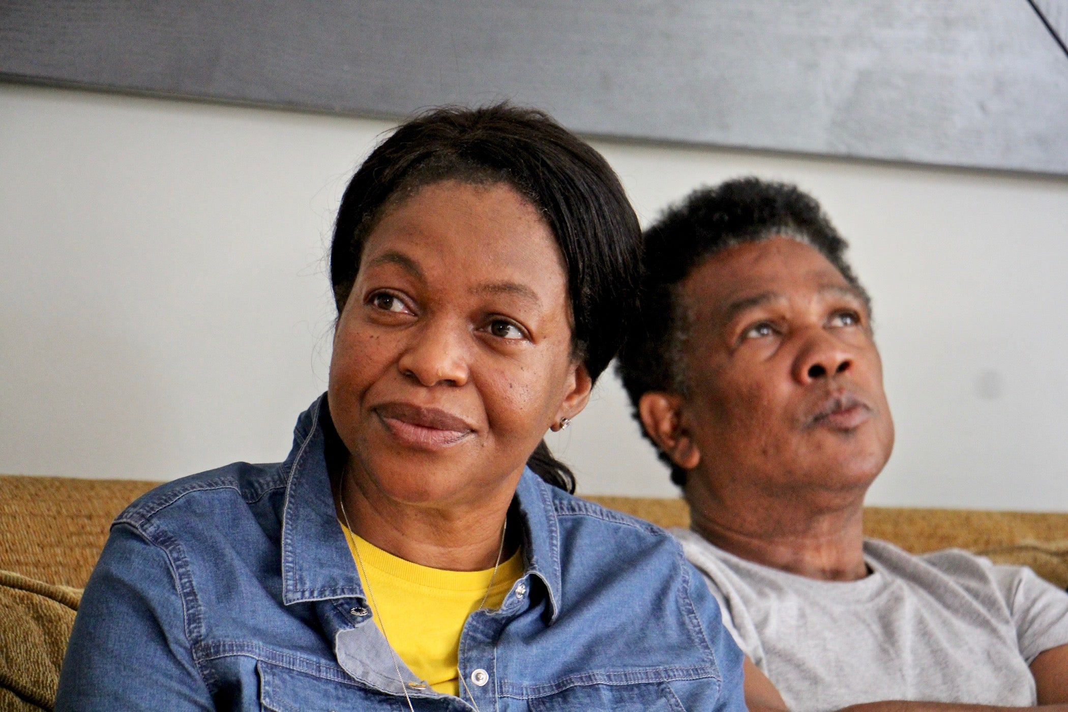 Oneita and Clive Thompson sit on a couch