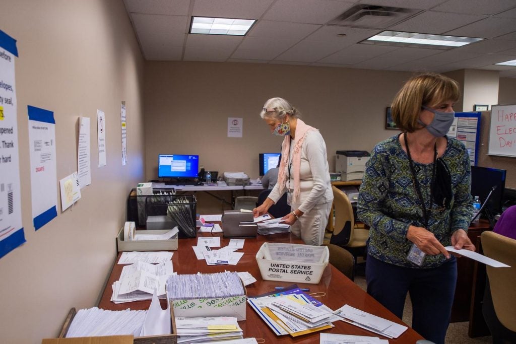 Erie County employees are seen here organizing mail ballots during the 2020 presidential election. “We would have had to go to county taxpayers several times without this,” Erie County Executive Director Kathy Dahlkemper wrote of the grant money. (Robert Frank for Spotlight PA)