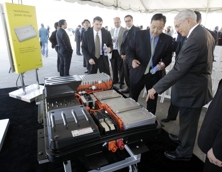 FILE- In this file photo made May 26, 2010, people look over the battery array of an all-electric Nissan Leaf in Smyrna, Tenn. Nissan North America, Inc. held its ground-breaking ceremony Wednesday for a lithium-ion battery plant as part of its plan to start building electric cars and eventually create up to 1,300 jobs in Tennessee. The auto industry calls it range anxiety: Drivers want electric cars but worry they won't have enough juice to make long trips. After all, what good is going green if you get stranded with a dead battery? It's a fear that automakers must overcome as they push to sell more battery-powered cars. So government and business are taking steps to reassure drivers by building up the nation's network of electric charging stations. (AP Photo/Mark Humphrey, File)