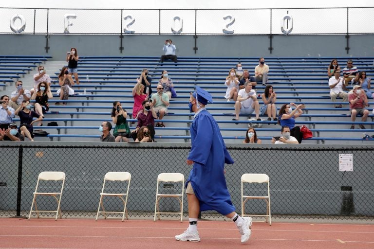 Students walks past applauding friends and family during a graduation ceremony at Millburn High School in Millburn, N.J., Wednesday, July 8, 2020. (AP Photo/Seth Wenig)