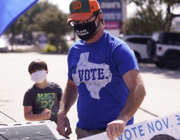 A supporter of Democratic presidential candidate former Vice President Joe Biden prepares for a Ridin' With Biden event Sunday, Oct. 11, 2020, in Plano, Texas. (AP Photo/LM Otero)