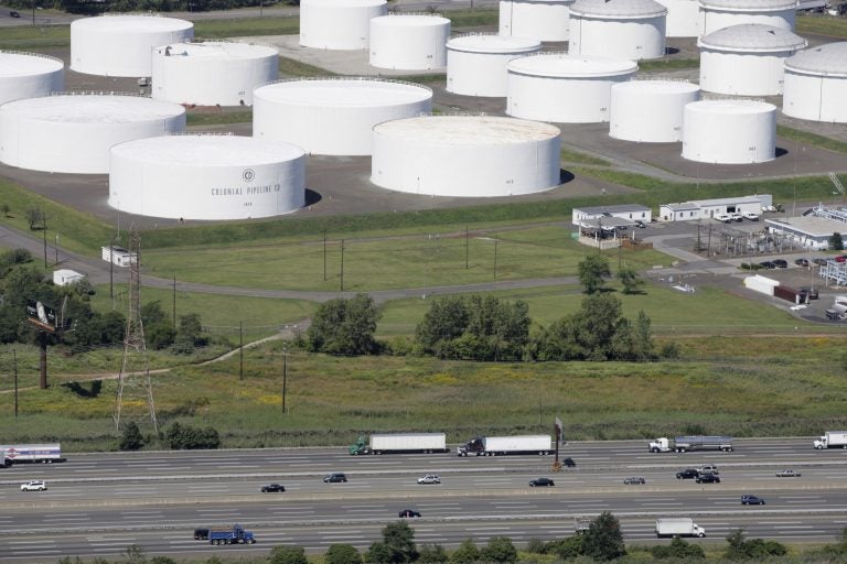 In this Sept. 8, 2008 file photo traffic on I-95 passes oil storage tanks owned by the Colonial Pipeline Company in Linden, N.J. A major pipeline that transports fuels along the East Coast says it had to stop operations because it was the victim of a cyberattack. Colonial Pipeline said in a statement late Friday that it “took certain systems offline to contain the threat, which has temporarily halted all pipeline operations, and affected some of our IT systems.” (AP Photo/Mark Lennihan, File)