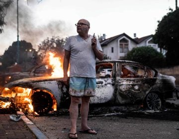 Jacob Simona stands by his burning car during clashes with Israeli Arabs and police in the Israeli mixed city of Lod, Israel Tuesday, May 11,2021. (AP Photo/Heidi Levine)