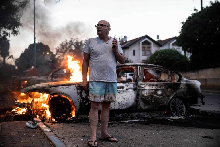 Jacob Simona stands by his burning car during clashes with Israeli Arabs and police in the Israeli mixed city of Lod, Israel Tuesday, May 11,2021. (AP Photo/Heidi Levine)