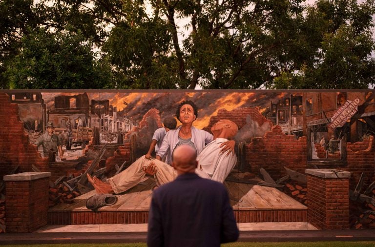 In this Thursday, May 27, 2021 file photo, Darius Kirk looks at a mural depicting the Tulsa Race Massacre in the historic Greenwood neighborhood ahead of centennial commemorations of the massacre in Tulsa, Okla. (AP Photo/John Locher)