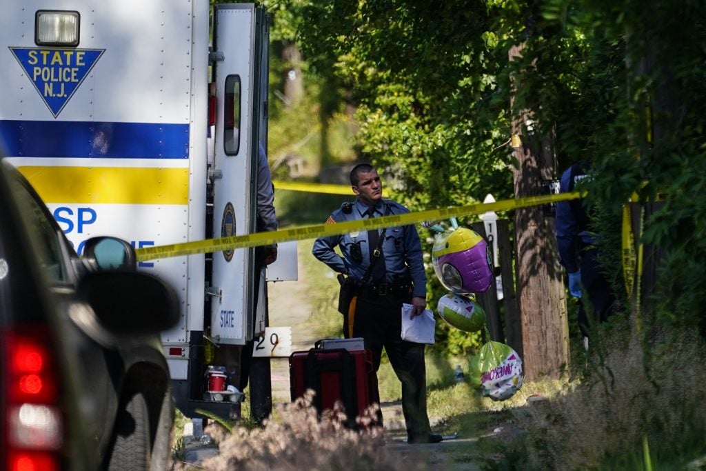 A police officer stands behind crime scene tape