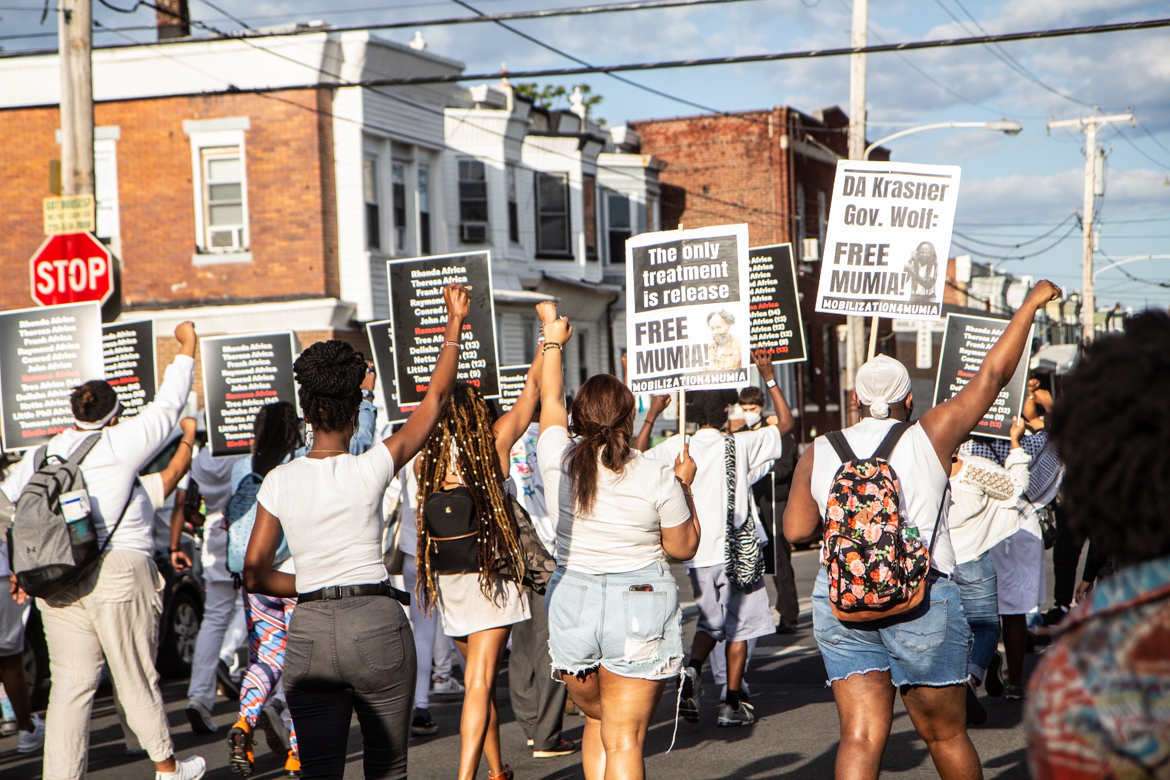 Protesters carrying signs with the names of the 11 members of the MOVE family