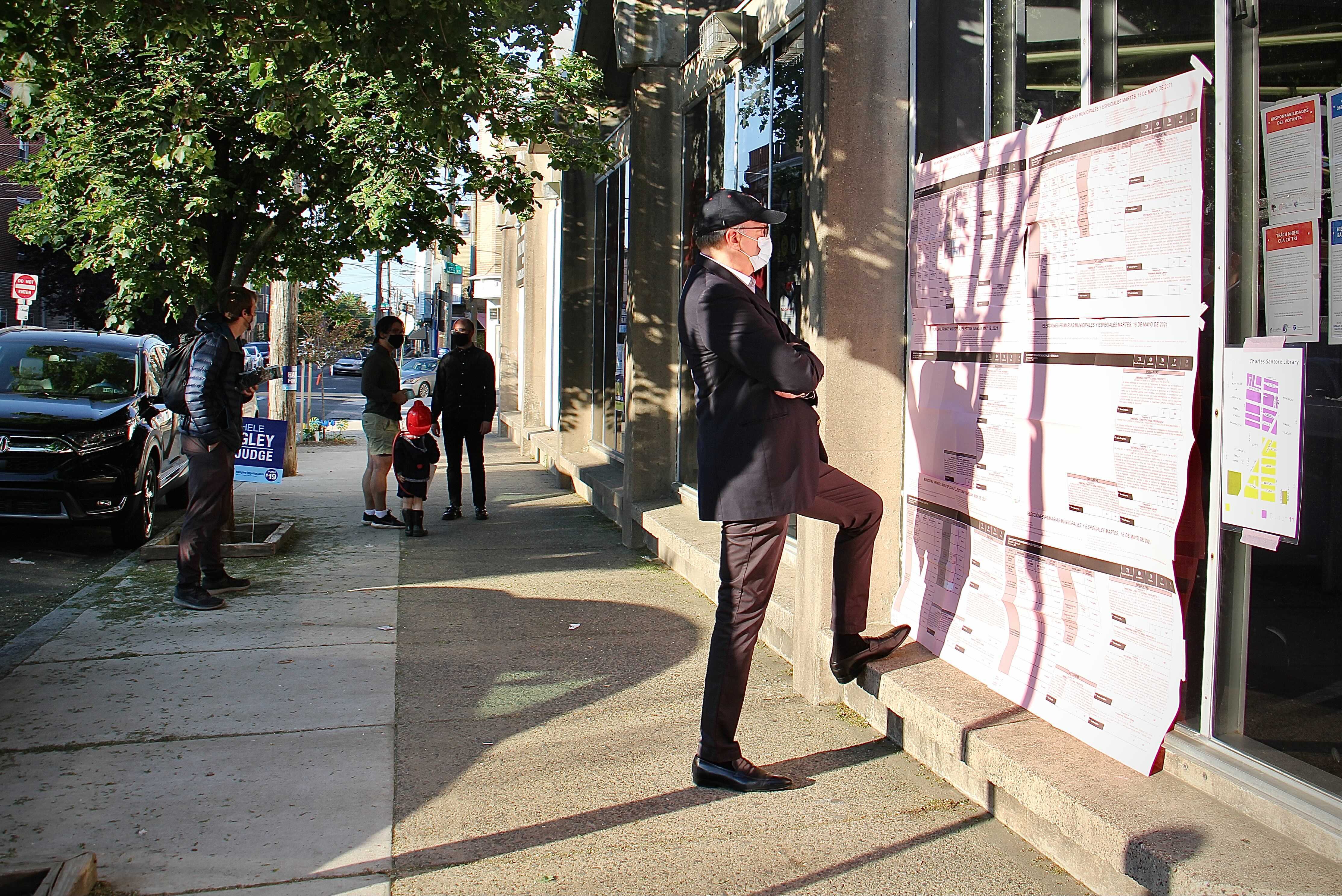 A voter reads the sample ballot poster outside the polling place at Santore Library