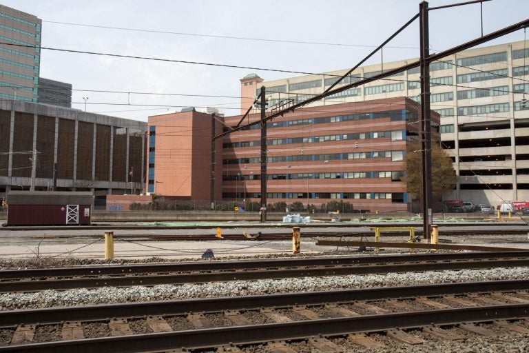 A building is seen beyond railroad tracks