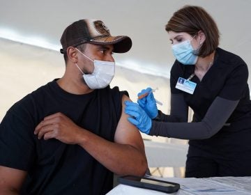 Juan Frutos receives a COVID-19 vaccine shot