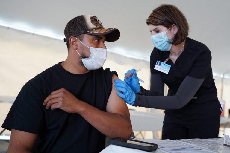 Juan Frutos receives a COVID-19 vaccine shot