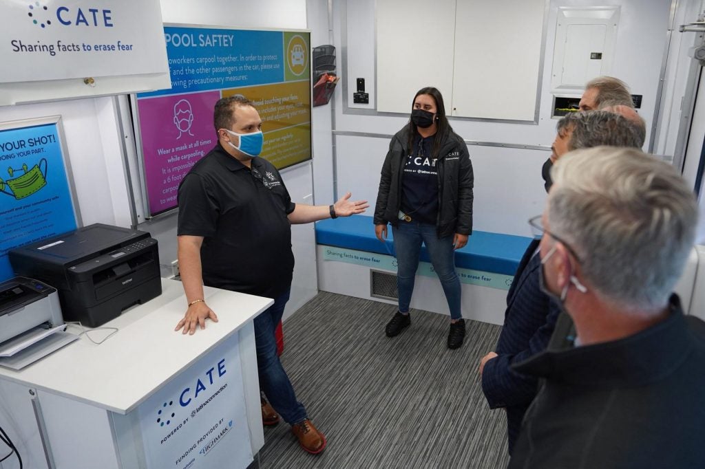 George Fernandez and others stand inside a mobile resource unit