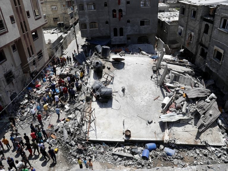 People gather near the rubble of destroyed residential building which was hit by Israeli airstrikes on Thursday in Beit Lahiya, Gaza Strip. (Adel Hana/AP)