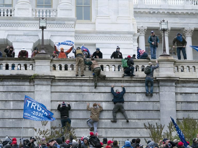 Supporters of President Donald Trump climb the west wall of the the U.S. Capitol on Jan. 6. (Jose Luis Magana/AP Photo)