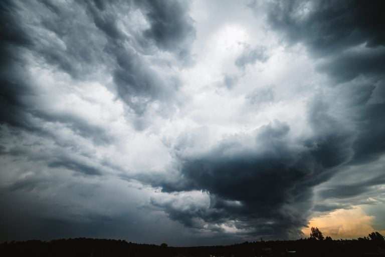 Sunny light through dark heavy thunderstorm clouds before rain