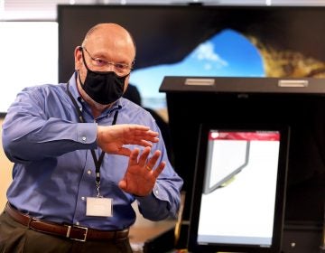 Bob Morgan gestures while wearing a face mask