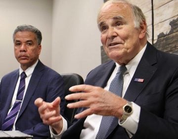 Ed Rendell gestures in the forefround; Carlos Vega sits in the background