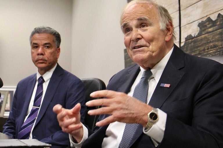 Ed Rendell gestures in the forefround; Carlos Vega sits in the background