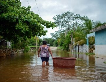 A woman from the Mayan community of Tecoh wades through the water in a flood caused by Tropical Storm Cristobal in the town of Tecoh, near Merida in Yucatan State, Mexico, in June 2020. (Luis Perez/AFP via Getty Images)