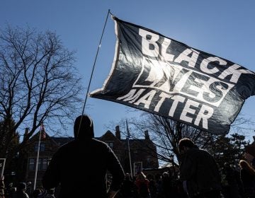 A man holds a Black Lives Matter flag during a protest