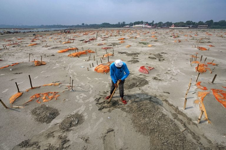 Rains have washed away the top layer of sand of shallow graves at a cremation ground on the banks of the Ganges River in Shringverpur, northwest of Allahabad, Uttar Pradesh, India. Coronavirus testing is limited in parts of rural India, but some of the people buried there are believed to have died of COVID-19. Rains have washed away the top layer of sand of shallow graves at a cremation ground on the banks of the Ganges River in Shringverpur, northwest of Allahabad, Uttar Pradesh, India. Coronavirus testing is limited in parts of rural India, but some of the people buried there are believed to have died of COVID-19. (Ritesh Shukla/Getty Images)