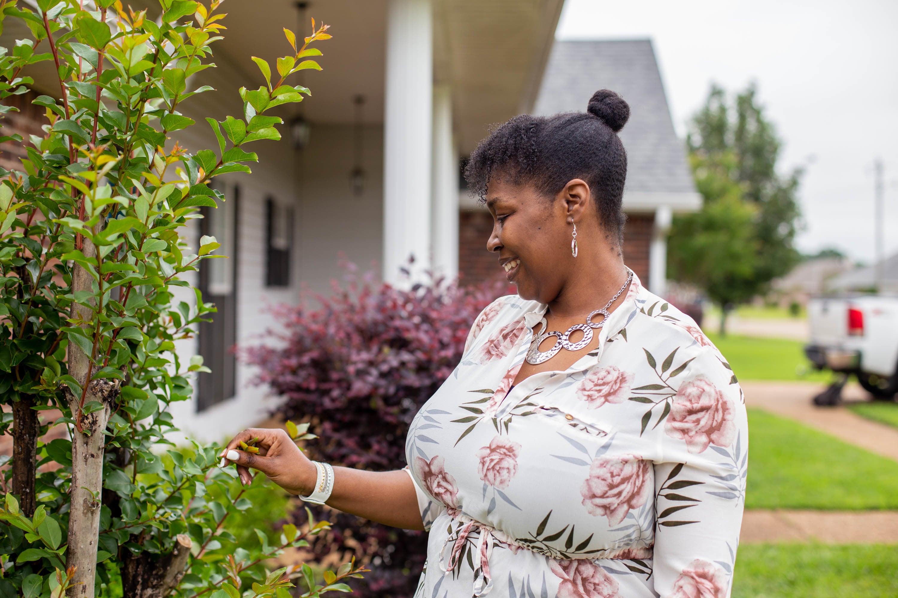 Tia Cunningham tends to plants in front of her home