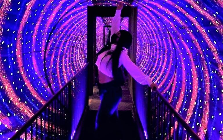 A Museum of Illusions visitor strikes a pose in the vortex tunnel