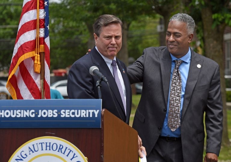 Interim Camden Mayor Vic Carstarphen, at right, who is running in the June 8 primary, shares a podium with US Rep. Donald Norcross, brother of South Jersey political power broker George Norcross, at a June 2 event to announce a $35 million grant to rebuild Ablett Village, a dilapidated Camden housing project. (Photo by April Saul for WHYY)