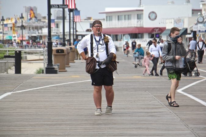 Falconer Ian Turner keeps tabs on his birds as he patrols the Ocean City boardwalk. The presence of birds of prey keeps away seagulls, who often harass outdoor diners. (Emma Lee/WHYY)