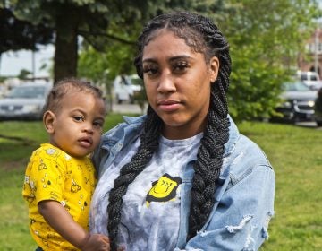 Asia Pratt holds her son Azi while standing outside