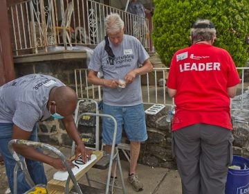 Volunteers with Rebuilding Together Philadelphia create address signs for homes on the 6000 block of Callowhill Street in the city’s Haddington neighborhood on June 4, 2021. (Kimberly Paynter/WHYY)