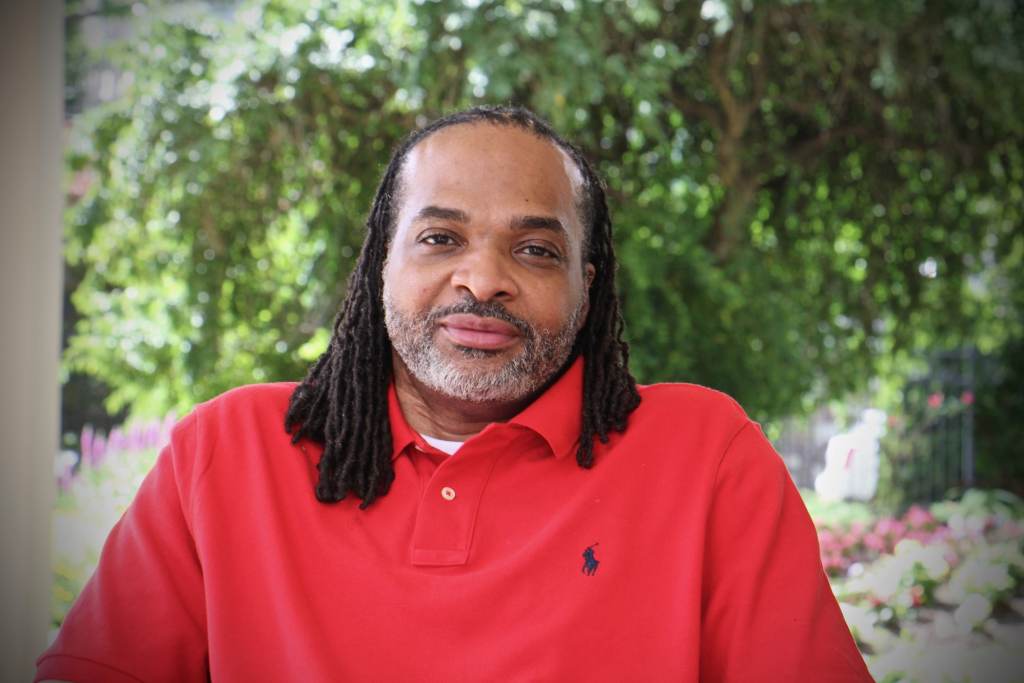 Charles Horton sits with a tree behind him