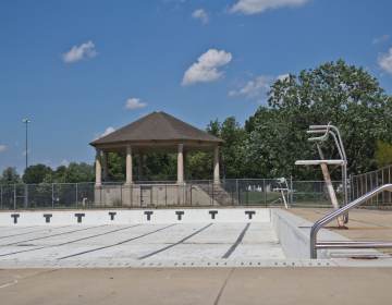 An empty pool is visible on a sunny day.