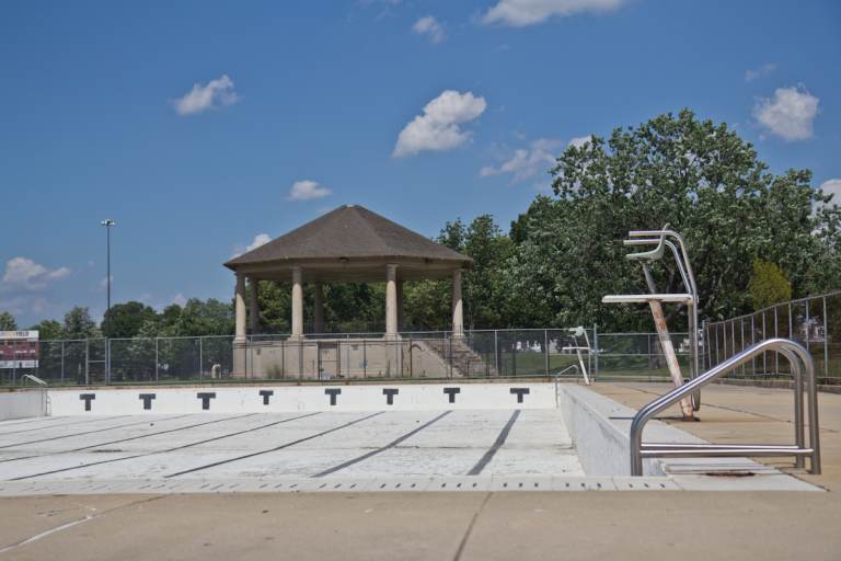 An empty pool is visible on a sunny day.