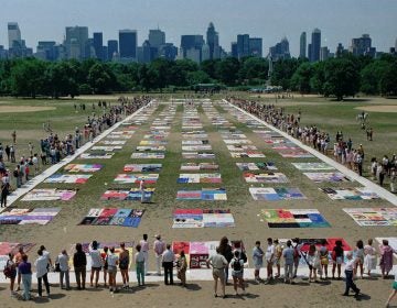 Onlookers watch as almost 1,500 quilt panels bearing the names of New York area residents who have died of AIDS are unfolded on the Great Lawn