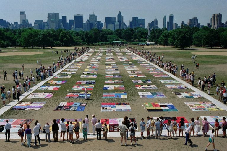 Onlookers watch as almost 1,500 quilt panels bearing the names of New York area residents who have died of AIDS are unfolded on the Great Lawn