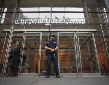 FILE - In this June 28, 2018, file photo, a police officer stands outside The New York Times building in New York. The Trump Justice Department secretly obtained the phone records of four New York Times journalists as part of a leak investigation, the newspaper said Wednesday, June 2, 2021. (AP Photo/Mary Altaffer, File)