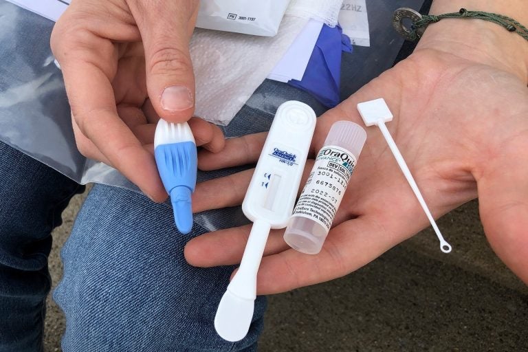 FILE - In this Tuesday, March 9, 2021 file photo, Solutions Oriented Addiction Response organizer Brooke Parker holds an HIV testing kit in Charleston, W.Va. The nonprofit group operates health fairs for residents, including syringe exchanges and HIV testing. Some researchers believe COVID-19 has derailed the fight against HIV, siphoning away health workers and other resources and setting back a U.S. campaign to decimate the AIDS epidemic by 2030. (AP Photo/John Raby)