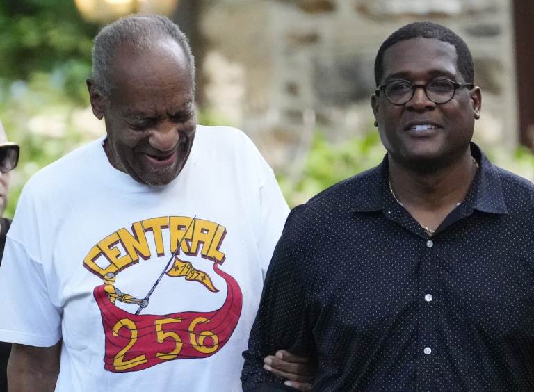 Comedian Bill Cosby, left, and spokesperson Andrew Wyatt approach members of the media gathered outside the home of the entertainer in Elkins Park, Pa., Wednesday, June 30, 2021.  (AP Photo/Matt Slocum)