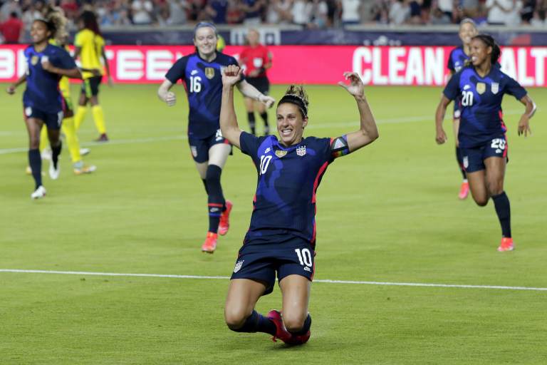 Carli Lloyd slides on astro turf during a soccer game