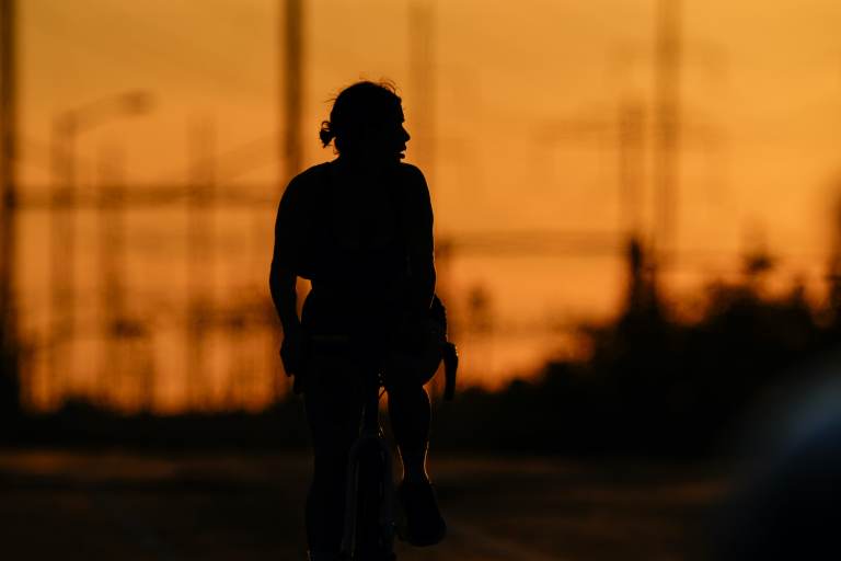 A cyclist rides in the day’s diminishing light