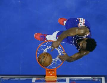 An overhead shot of Joel Embiid dunking a basketball during a playoff game