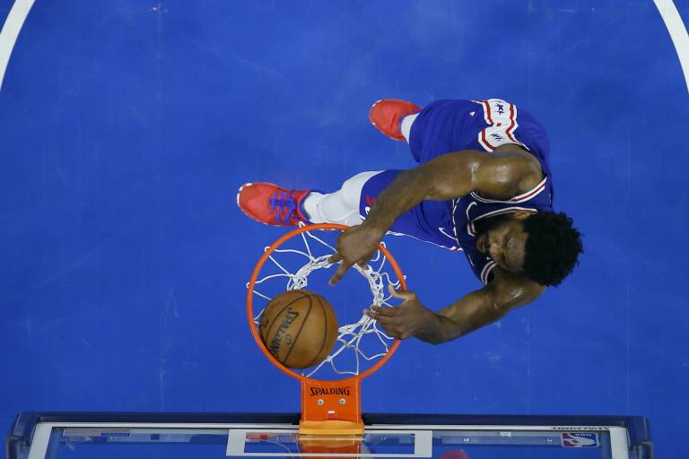 An overhead shot of Joel Embiid dunking a basketball during a playoff game